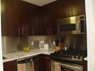 Kitchen with marble countertop, wood cabinets and stainless steel GE Profile appliances