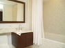 Spa inspired bathroom with porcelain tile and Kohler tub with mosaic glass surround